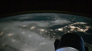 a lights from cities along the coast of a peninsula are seen at night from space