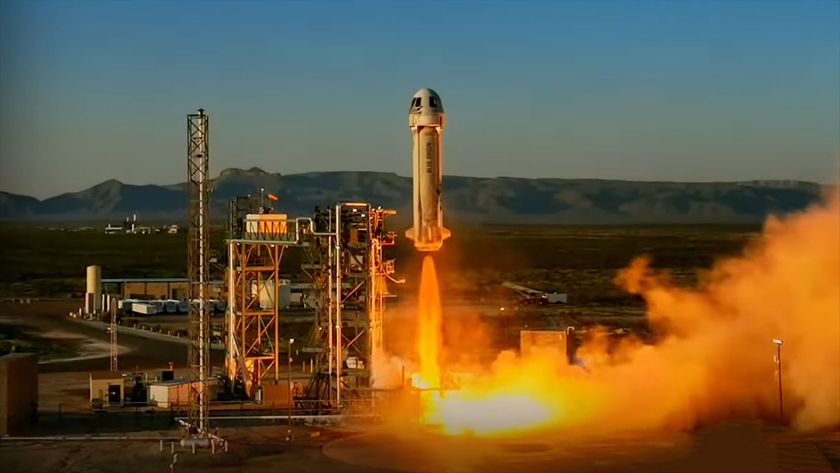 a white rocket lifts off from a desert launch site into the dawn sky