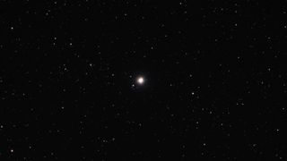 A bright dot of a star in the darkness of space with stars all around.